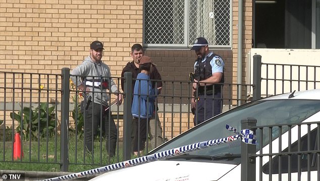 Police are shown talking to residents of the same Liverpool unit block after a man was shot in his driveway in October 2022.